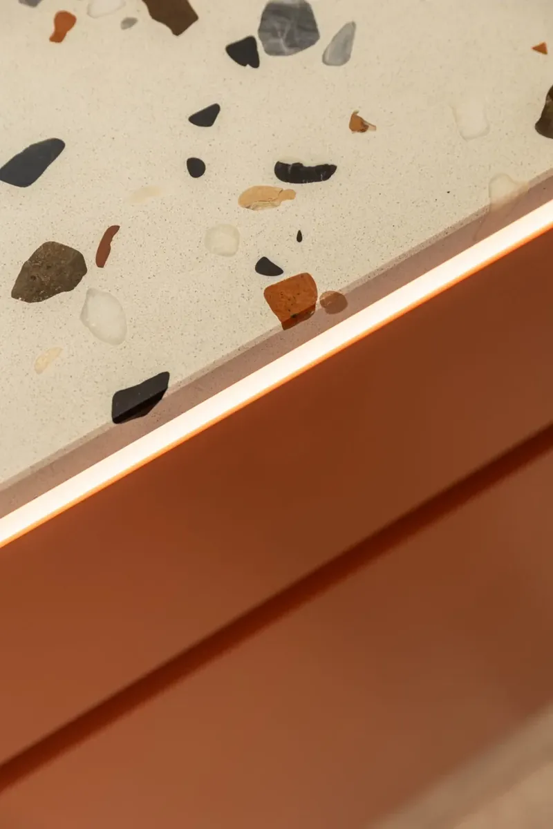 Szczedrzyk house: terrazzo worktop edge with a glowing light line over terracotta fronts